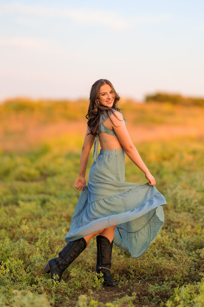 high school senior wearing a dress and walking through field in CO